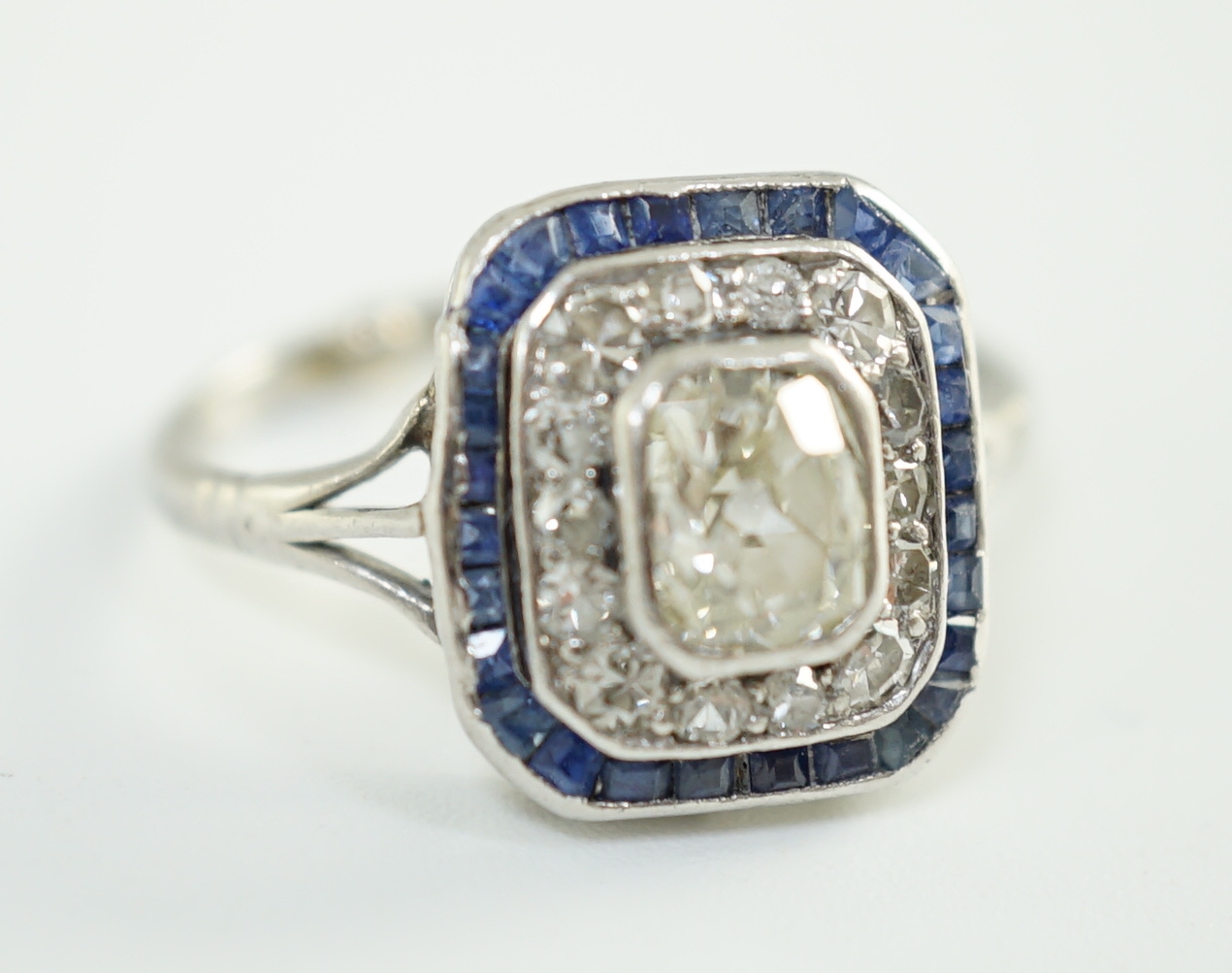 An Art Deco platinum, diamond and sapphire set rectangular cluster ring